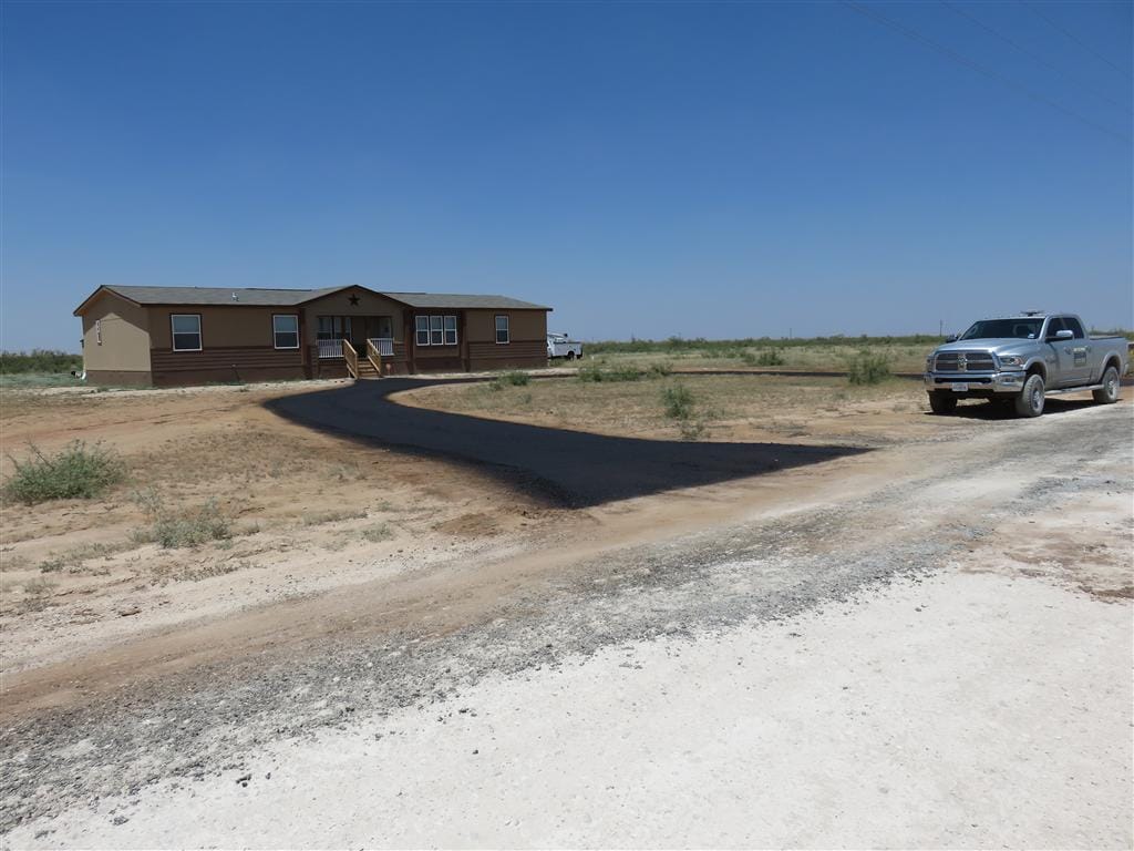 New asphalt circle driveway on an acreage lot